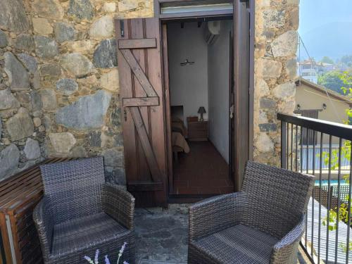 two chairs sitting on the balcony of a house at Enipnion Apartments in Kakopetria