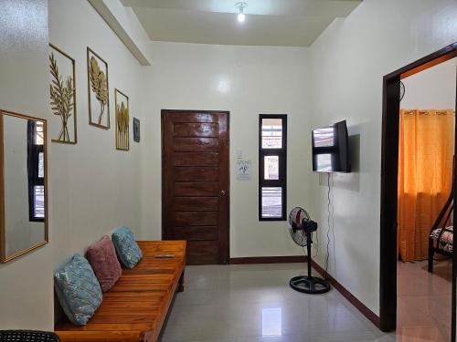 a living room with a wooden bench and a door at budget transient house near sm Lucena 6pax in Lucena