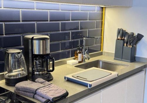 a kitchen counter with a mixer next to a sink at 5min to Dubai mall Burj Khalifa with Canal View in Dubai