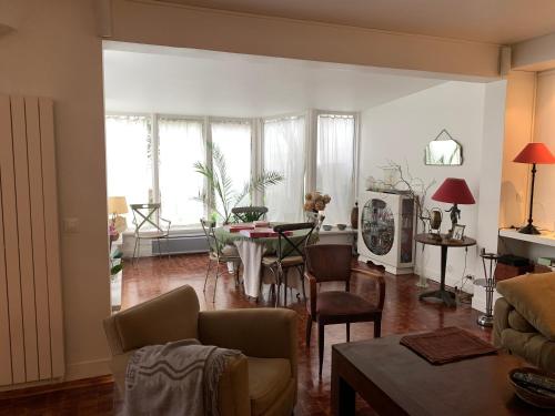 un salon avec un canapé, une table et des chaises dans l'établissement Maison de campagne à Paris, à Paris