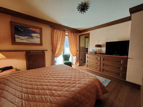 a bedroom with a bed and a flat screen tv at Appartamento Grand Soleil in Pré-Saint-Didier