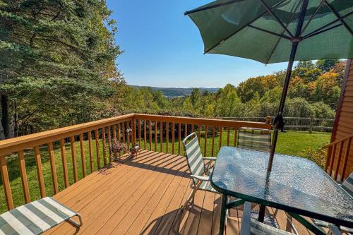 a table and chairs on a deck with an umbrella at Green Mountain Sunrise in Dover
