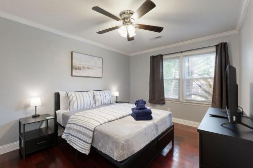 a bedroom with a bed and a ceiling fan at Palmetto Charm Oasis in Charleston