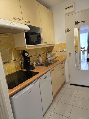 une cuisine avec un évier et une cuisinière four supérieur dans l'établissement Olivier, au Lavandou