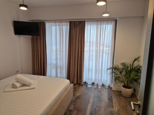 a bedroom with a bed and a large window at Apartamente Vista Lago e Mare in Eforie Nord