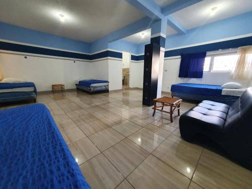 a living room with two beds and a couch at Hostal Corazón de San Pedro in San Pedro La Laguna