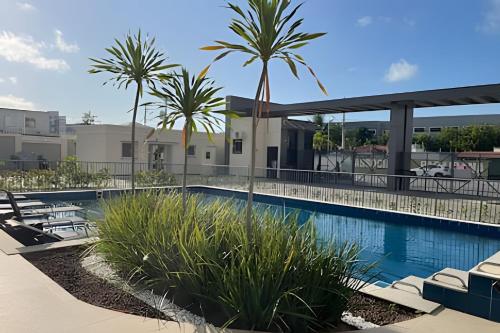 a swimming pool with palm trees in a building at (1506)Apt 2 Quartos Cabedelo- Ponta de Campina in Tambauzinho