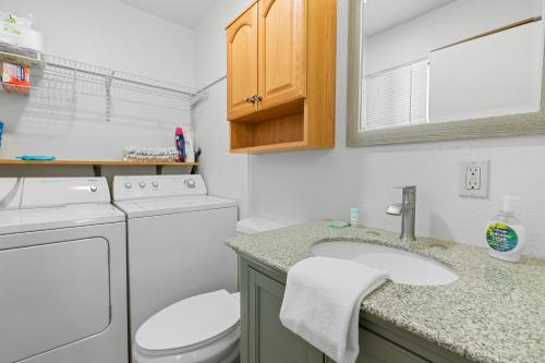 a small bathroom with a washer and dryer at Woodland Escape - Quiet Area, Walk to Hiking Trails & Park! in Big Bear City