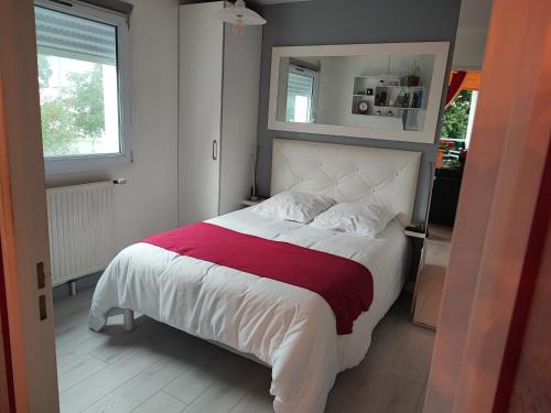 une chambre avec un grand lit avec une couverture rouge dans l'établissement Horizon, à Vannes