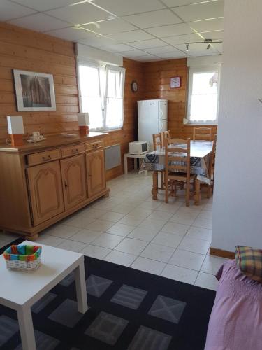 une cuisine et une salle à manger avec une table et un réfrigérateur dans l'établissement F2 lumineux en centre ville - Gerardmer, à Gérardmer