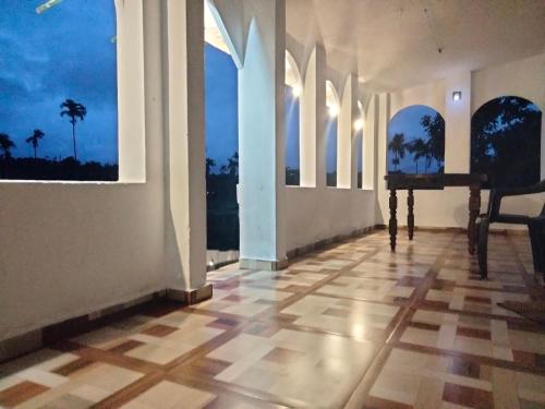 an empty room with windows and a piano on the floor at JK Home stay in Sultan Bathery