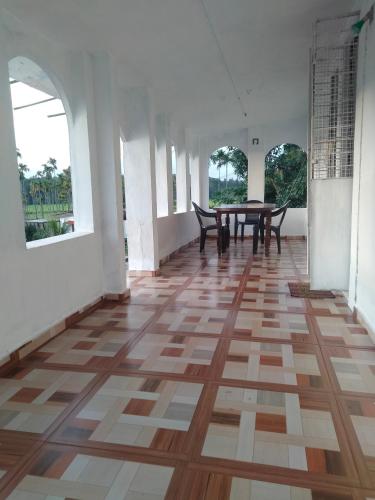 an empty room with a wooden floor and a table at JK Home stay in Sultan Bathery