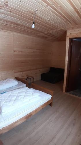 a bedroom with a bed in a wooden cabin at Guest House Brili in Ghebi