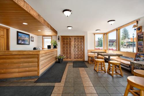 a restaurant with tables and chairs and windows at Nordic Lodge in Steamboat Springs
