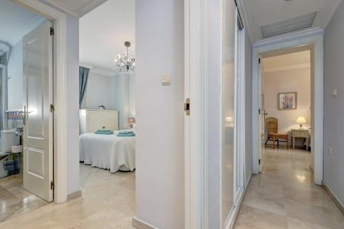 a hallway with a room with a bed and a chandelier at Banana Beach primera línea de playa in Marbella