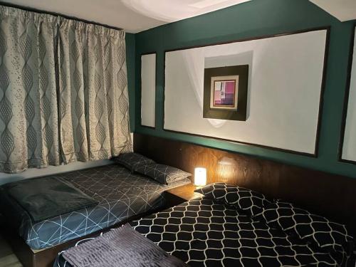 a small room with two beds and a window at Sunset Greens Haven in Alor Gajah