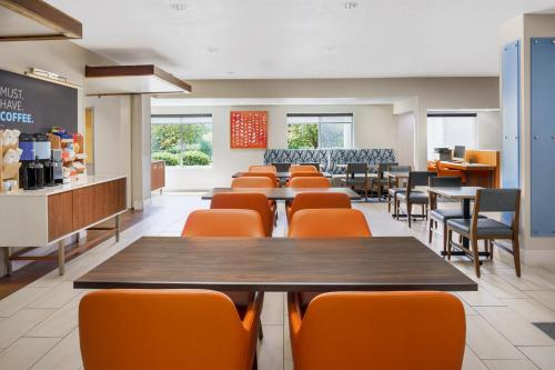 a dining room with tables and chairs in a cafeteria at Holiday Inn Express Irondequoit by IHG in Rochester