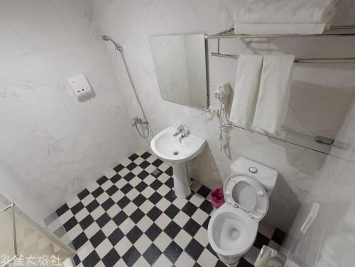 Łazienka z białą toaletą i umywalką w obiekcie Peacock hotel w mieście Daxi