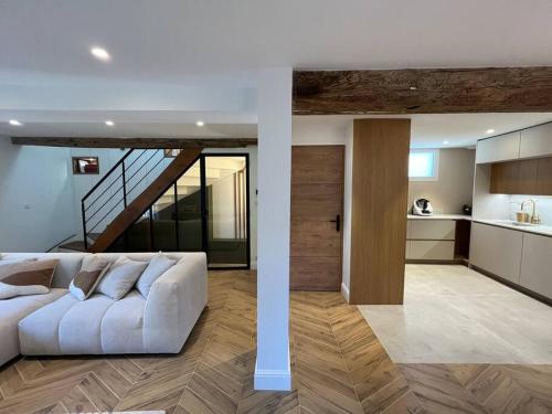 un salon avec un canapé blanc et une cuisine dans l'établissement Le Triplex du Quai, à Bouchemaine