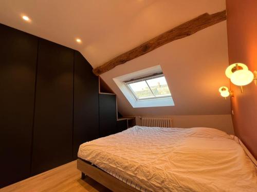 une chambre avec un lit et une fenêtre dans l'établissement Le Triplex du Quai, à Bouchemaine