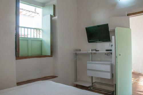 a small room with a bed and a television at La Nube Posada in Barichara