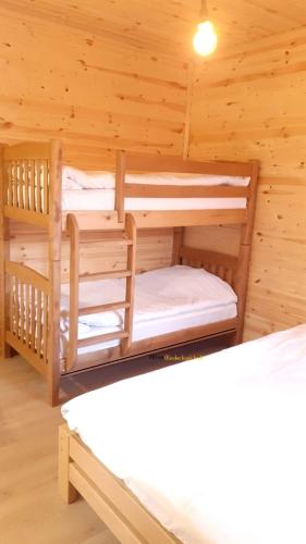 a bedroom with two bunk beds in a log cabin at Guest House Brili in Ghebi