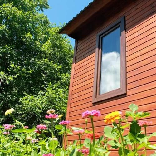a building with a window and flowers in front of it at Guest House Brili in Ghebi