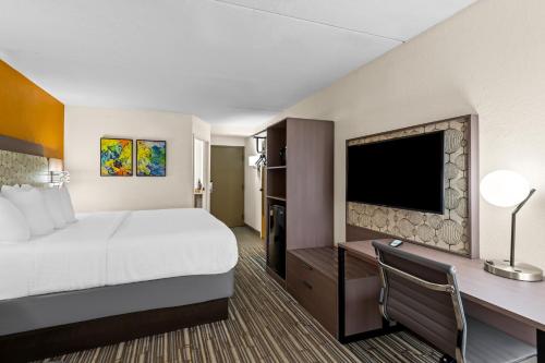 a hotel room with a bed and a flat screen tv at Spark by Hilton Syracuse Carrier Circle in East Syracuse