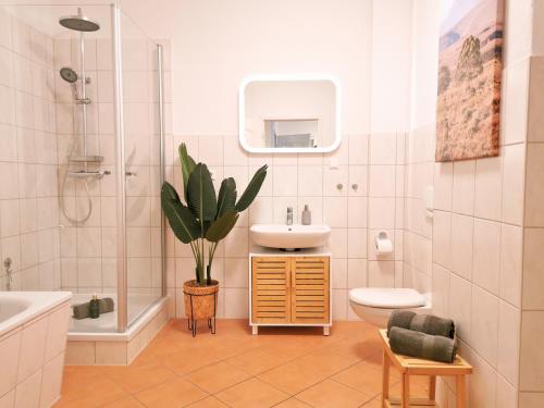 a bathroom with a sink and a toilet and a plant at Fynbos Apartments am Theater, Loggia, Parkplatz in Meißen