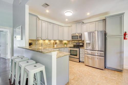 a kitchen with white cabinets and white appliances at Less Than 1 Mi to Beach - Home with Deck and Yard in Waveland! in Waveland