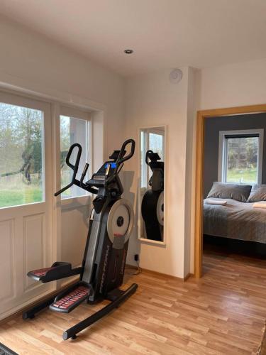 a room with a treadmill and a bedroom with a bed at 4-room spacious condo w patio in Reykjavík