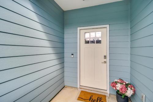 a blue house with a white door and flowers at Less Than 1 Mi to Beach - Home with Deck and Yard in Waveland! in Waveland