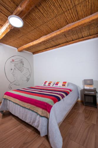 a bedroom with a bed with a colorful blanket at Puna Hostel in San Pedro de Atacama