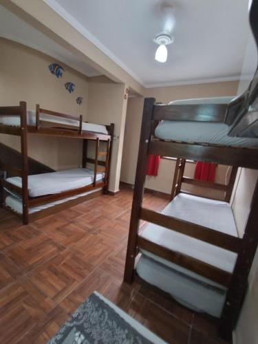 Zimmer mit 3 Etagenbetten und Holzboden in der Unterkunft Apto no Centro de Bertioga, próx a Praia da Enseada e da Balsa com acesso a Prainha Branca, Acomoda até 6 pessoas in Bertioga