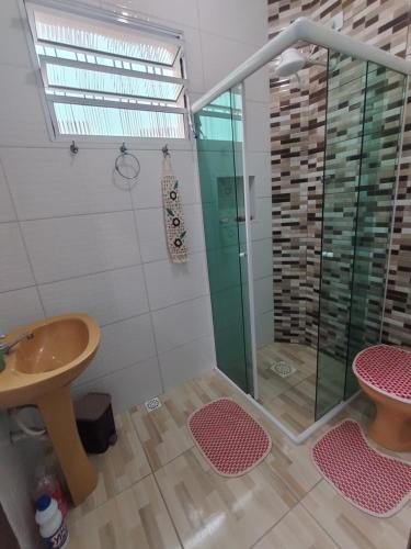 ein Badezimmer mit einer Glasdusche mit Waschbecken in der Unterkunft Apto no Centro de Bertioga, próx a Praia da Enseada e da Balsa com acesso a Prainha Branca, Acomoda até 6 pessoas in Bertioga