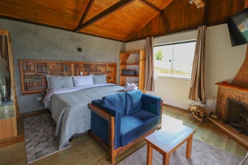 ヴィスコンデ・デ・マウアーにあるCaju da Barra chaléのベッドルーム(大型ベッド1台、青い椅子付)
