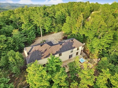an overhead view of a house in the woods at Blue Hill Pool spa game room mountain view in Morin Heights