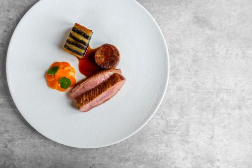 a white plate with food on a table at Bunchrew House Hotel in Inverness