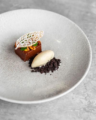 a white plate with a piece of chocolate and a treat at Bunchrew House Hotel in Inverness