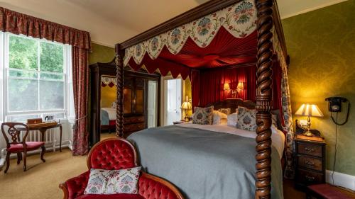 a bedroom with a large canopy bed and a chair at Bunchrew House Hotel in Inverness