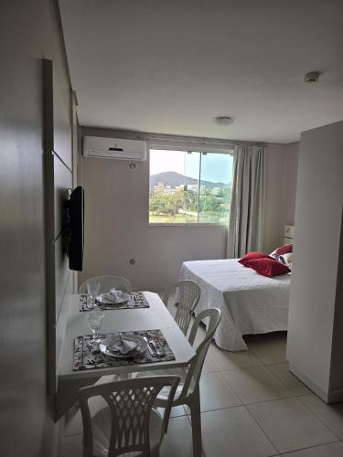 a room with a table and chairs and a bed at Residencial Flórida I in Bombinhas