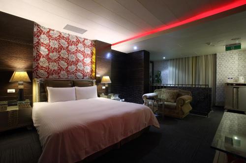 a hotel room with a bed and a chair at Crystal Business Motel in Hsinchu City