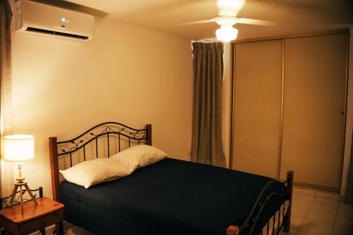 a bedroom with a bed and a lamp and a window at Residenciales H1 & H2 - Breakfast & Room Service - Airport close in Santiago de los Caballeros