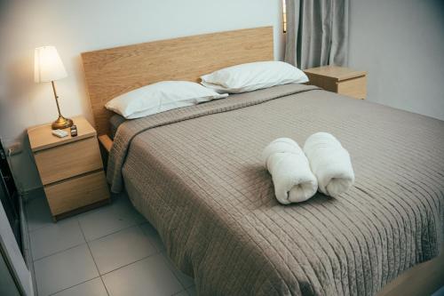a bedroom with a bed with two white towels on it at Residenciales H1 & H2 - Breakfast & Room Service - Airport close in Santiago de los Caballeros