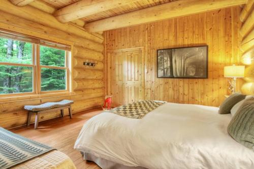 a bedroom with a bed in a log cabin at Blue Moose Private pool spa sauna lake access in Wentworth