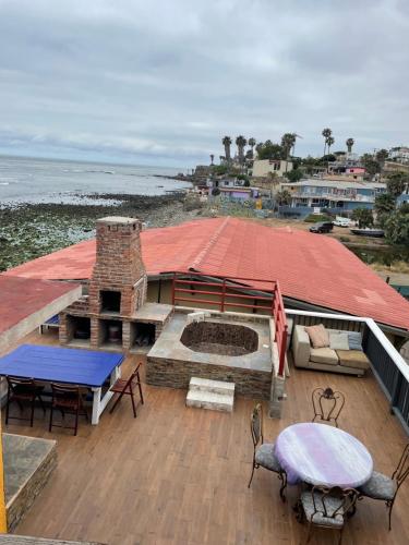 ロサリトにあるK38 Rosarito Sea Houseのレンガ造りの暖炉とテーブルと椅子のあるデッキ