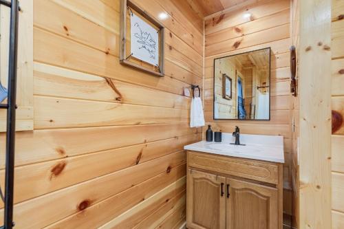 a bathroom with a sink and a mirror at Fully Loaded Cabin In Heart Of Pigeon Forge in Pigeon Forge