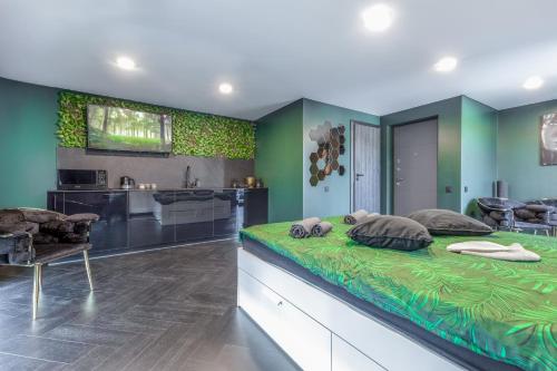 a green bedroom with a large bed and a kitchen at Apartments in Kaunas city centre with Jacuzzi bath in Kaunas