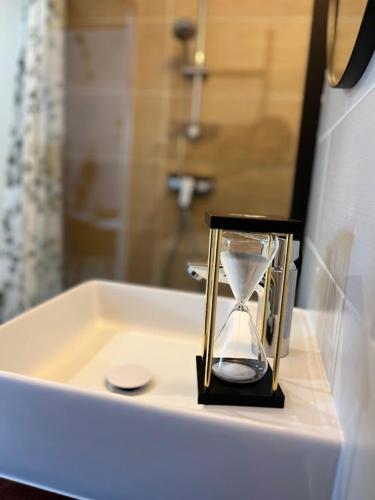 a sand timer sitting on top of a bathroom sink at La Grange de Marcel in Saint-Pol-de-Léon