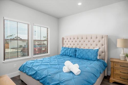 ein Schlafzimmer mit einem blauen Bett mit zwei weißen Handtüchern darauf in der Unterkunft Eagle's Villa - Hot Tub 5 Min to Main in Fredericksburg